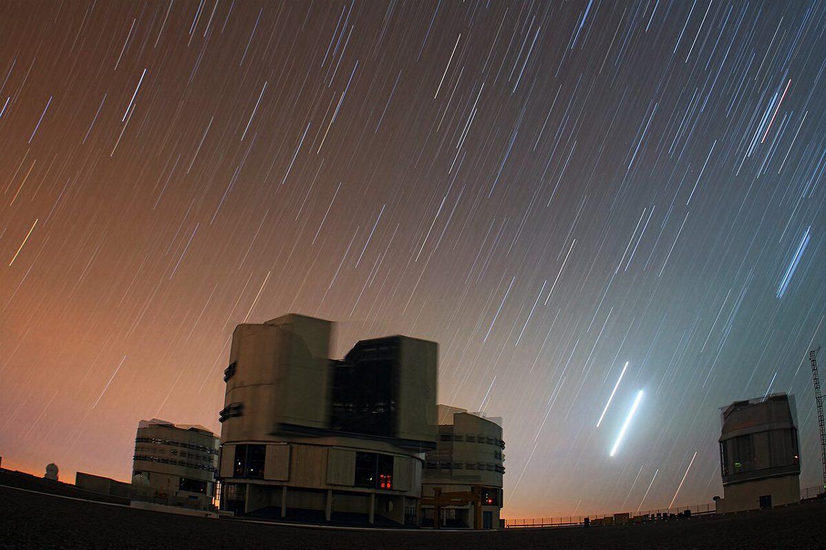 長い露光で、星が無数の線になり、金星と木星が明るい太い線になった夜空と望遠鏡の建物