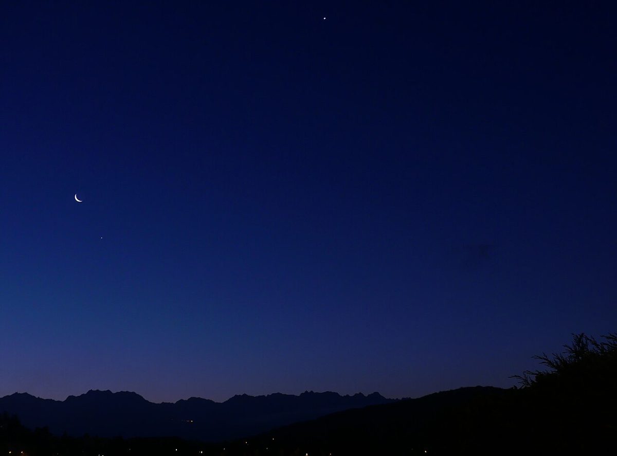 夜明け前の空に光る細い月と、明るい金星と木星