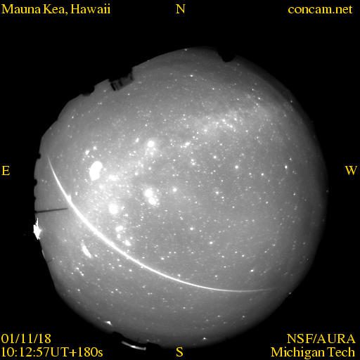 全天カメラの円い画像に、明るい流星の長い軌跡が写っている