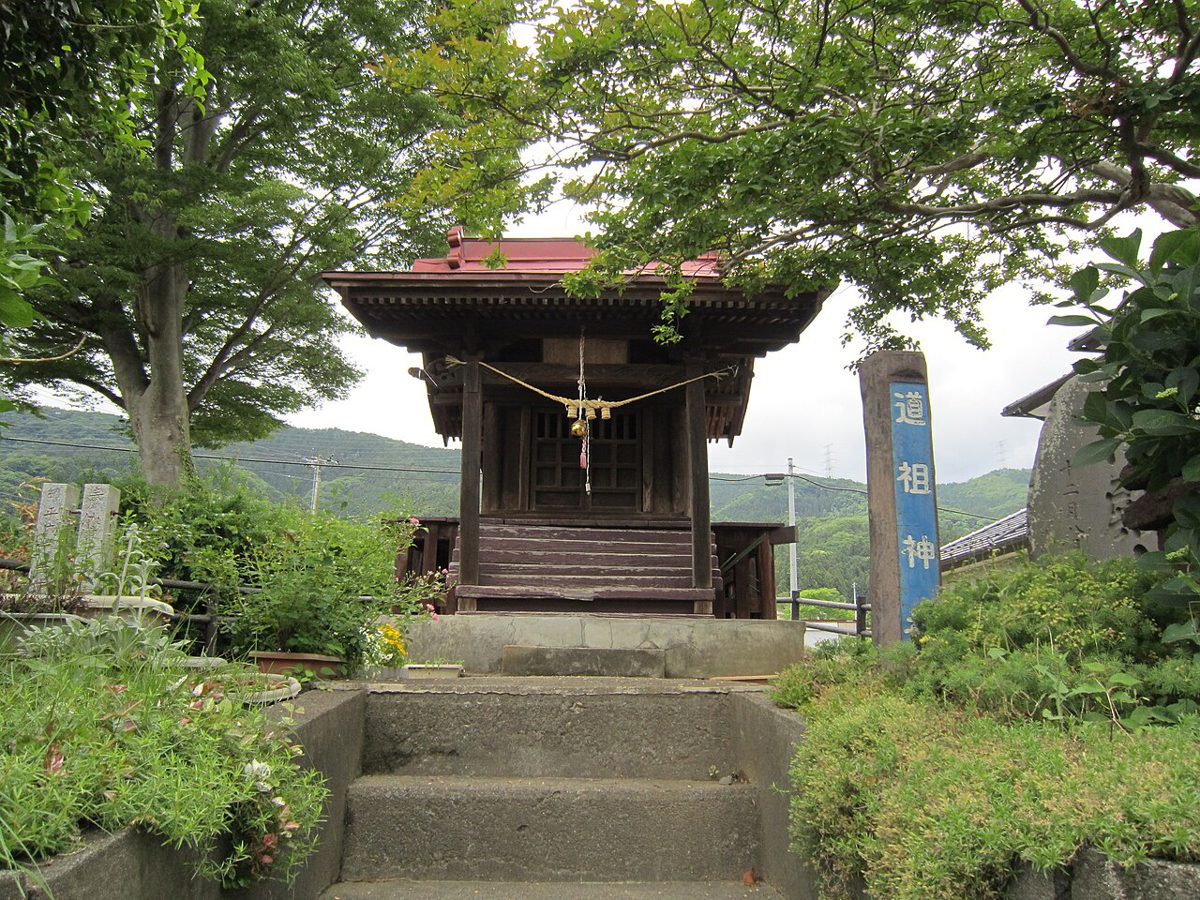 石段の上に建つ小さなお堂と「道祖神」と書かれた標柱