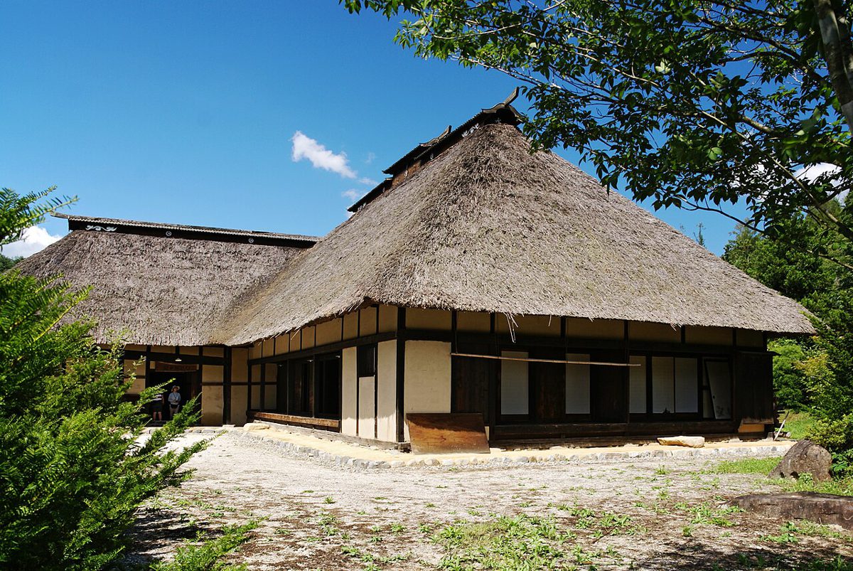 茅葺き屋根の古い農家と庭