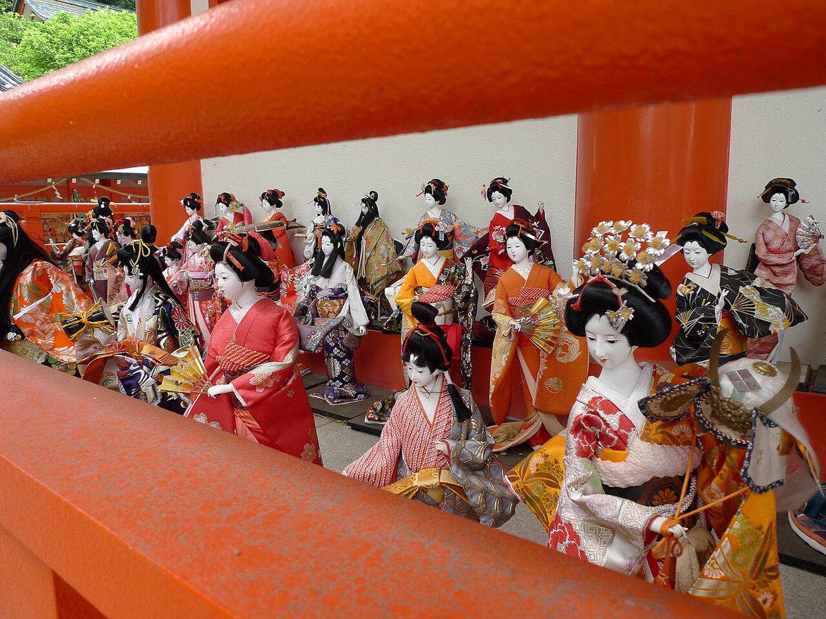 朱色の柵の向こうに、着物姿の日本人形がたくさん並んでいる