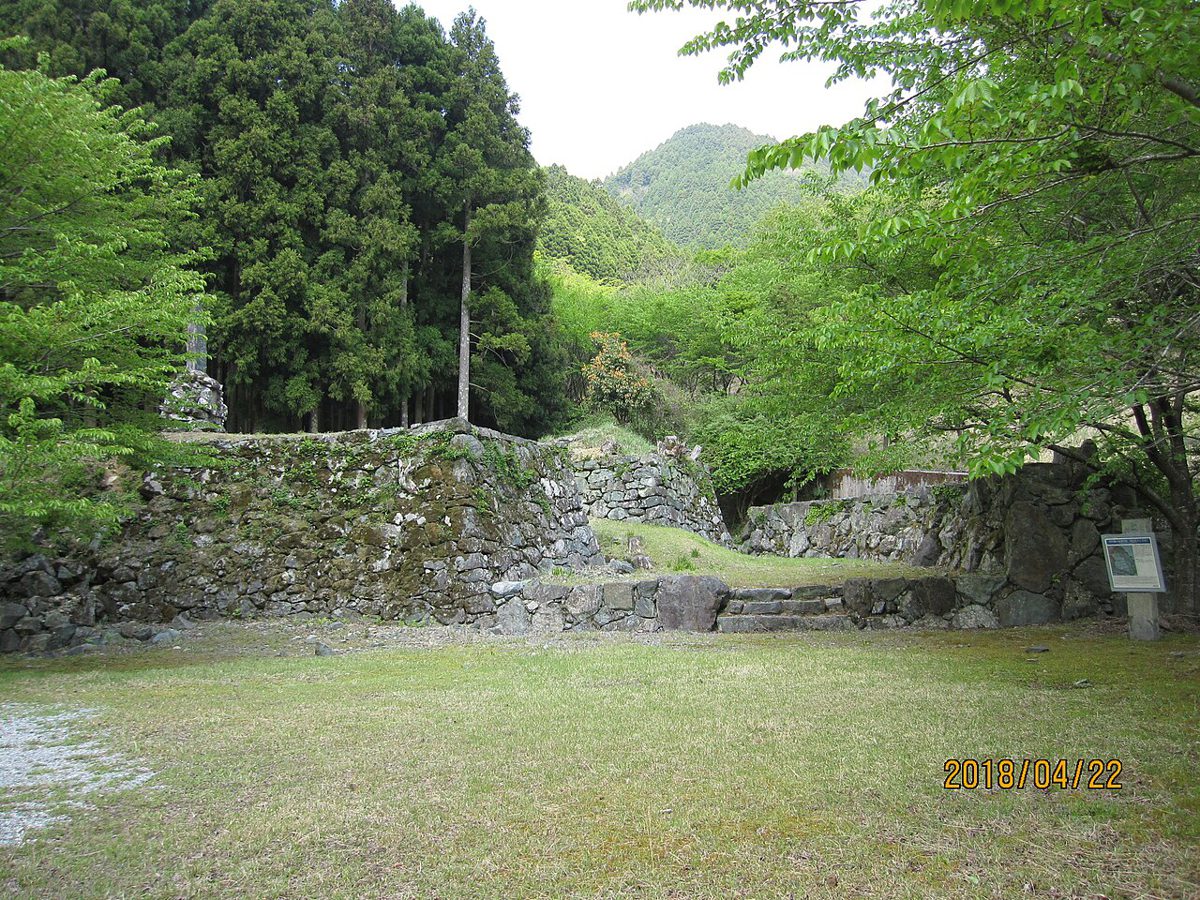 木立に囲まれた芝生の広場の奥に、苔むした石垣が残る