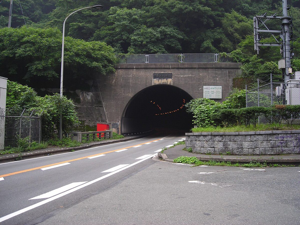 山の斜面に開いた、二車線の道路の新しいトンネルの入口