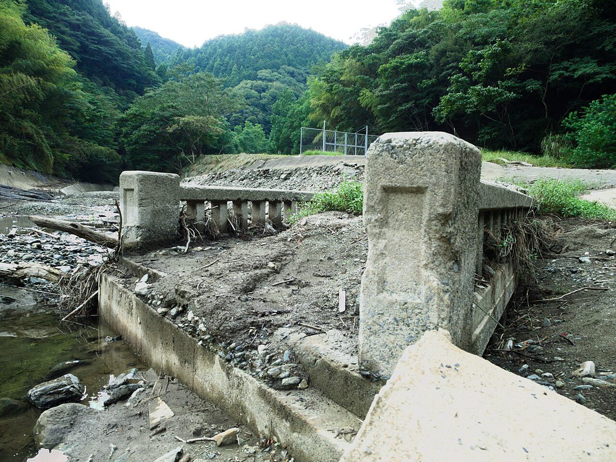 干上がった川底に、古いコンクリートの橋の欄干が泥をかぶって残っている