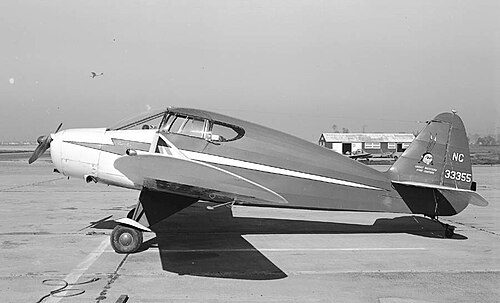飛行場に止まる、尾翼にNC 33355と書かれた単発の小型機