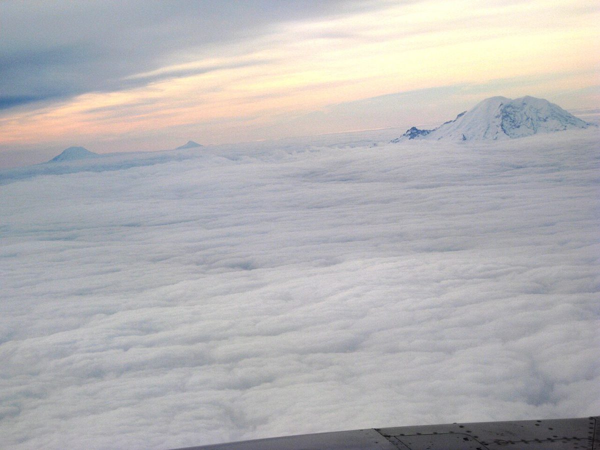 雲海の上に頭を出す、雪をかぶった火山の峰々