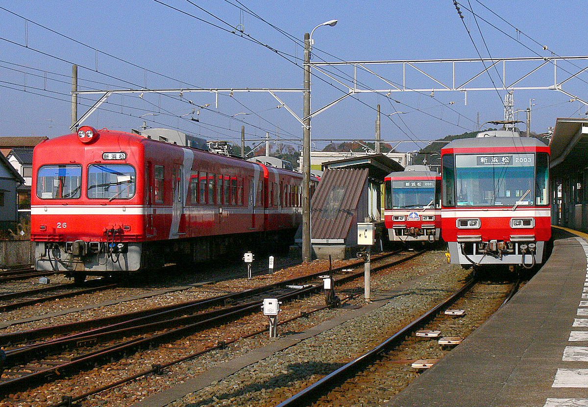 駅に並んで止まる赤い車体の遠州鉄道の電車3編成