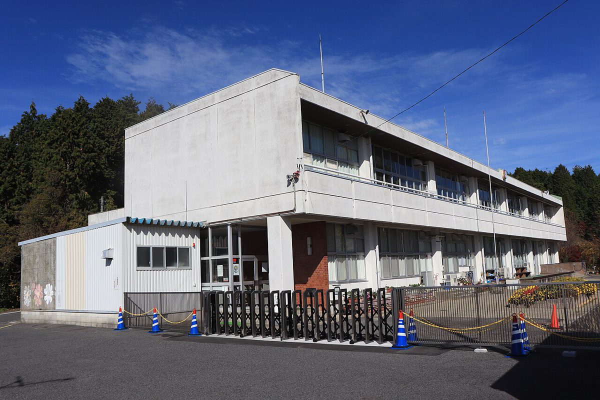 山あいに建つ2階建ての鉄筋コンクリートの小学校の校舎