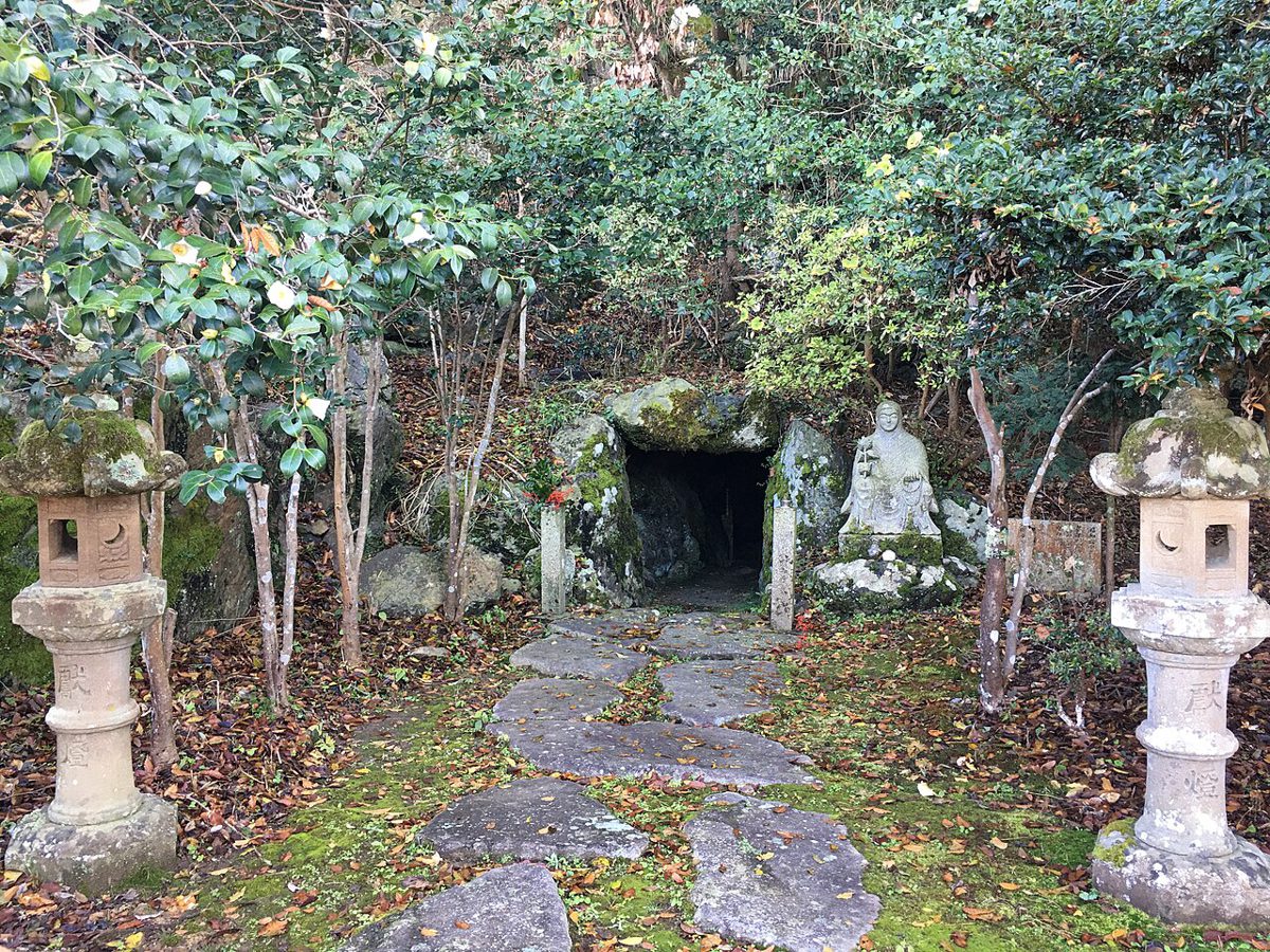 岩肌に口を開けた小さな洞窟と、その前の柵
