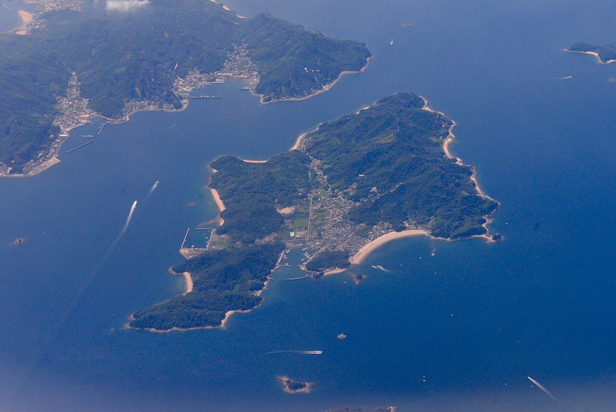 上空から見た瀬戸内海の島々。緑の島の海岸に砂浜と集落が見える