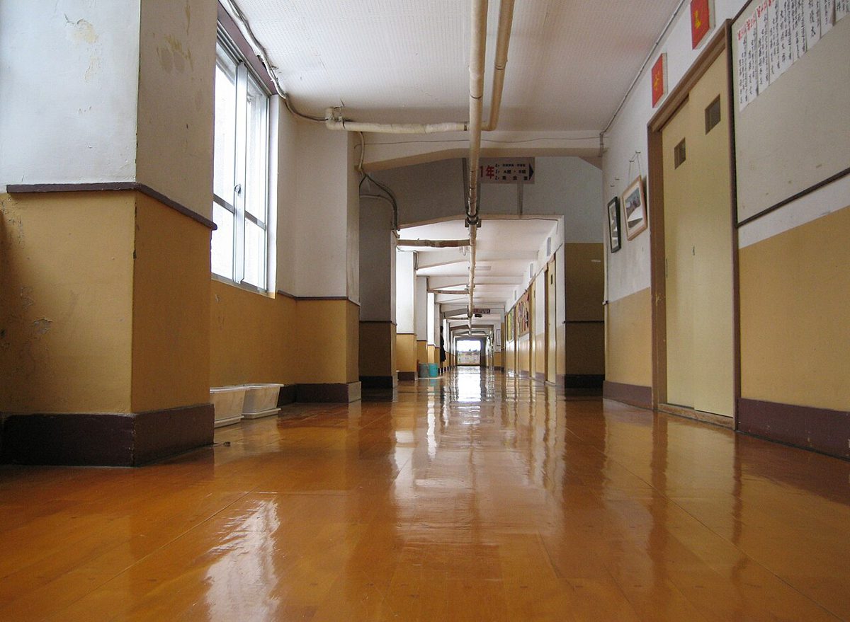 床すれすれの低い位置から見た、木の床が長く続く学校の廊下
