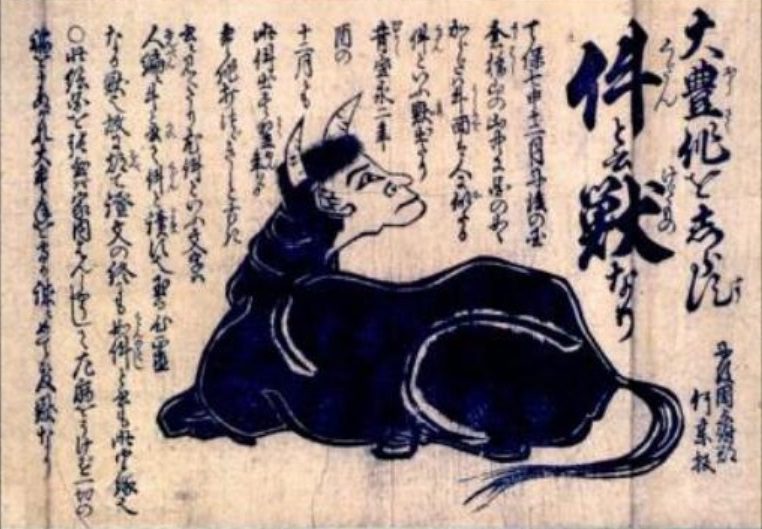 人の顔をした黒い牛が横たわる木版刷りの絵と、そのまわりの文字